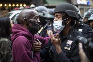 FILE - In this June 2, 2020 file photo, a protester and a police officer shake hands in the middle of a standoff at a rally in New York, calling for justice over the death of George Floyd, a Black man who died under the knee of a white police officer in Minneapolis on May 25. (AP Photo/Wong Maye-E, File) FILE - In this June 2, 2020 file photo, a protester and a police officer shake hands in the middle of a standoff at a rally in New York, calling for justice over the death of George Floyd, a Black man who died under the knee of a white police officer in Minneapolis on May 25. (AP Photo/Wong Maye-E, File)