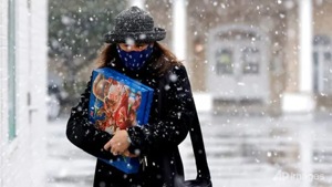 A woman walks in the snow while shopping on Brookside in Tulsa, Okla.(AP) A woman walks in the snow while shopping on Brookside in Tulsa, Okla.(AP)