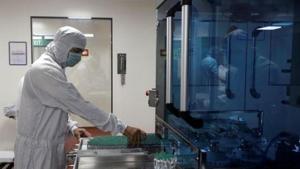 An employee in PPE removes vials of AstraZeneca's Covishield inside a lab at Serum Institute of India, in Pune, India.(REUTERS) An employee in PPE removes vials of AstraZeneca's Covishield inside a lab at Serum Institute of India, in Pune, India.(REUTERS)