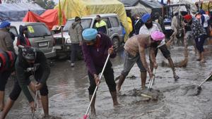 Demonstrators clearing a stretch of rainwater and mud on a rainy day at Singhu border during protests against new farm laws, near New Delhi on Sunday.(Vipin Kumar/HT PHOTO) Demonstrators clearing a stretch of rainwater and mud on a rainy day at Singhu border during protests against new farm laws, near New Delhi on Sunday.(Vipin Kumar/HT PHOTO)