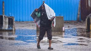 A man covers himself with a plastic sheet during heavy rain near Sarai Kale Khan in New Delhi.(Amal KS/HT PHOTO) A man covers himself with a plastic sheet during heavy rain near Sarai Kale Khan in New Delhi.(Amal KS/HT PHOTO)