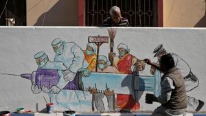 A man applies finishing touches to graffiti representing a vaccine, amidst the spread of coronavirus disease (Covid-19) in Kolkata, India, January 2, 2021.(REUTERS) A man applies finishing touches to graffiti representing a vaccine, amidst the spread of coronavirus disease (Covid-19) in Kolkata, India, January 2, 2021.(REUTERS)