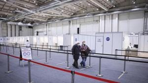 Two seniors walk through the Immunization Center at the Exhibition Halls for their vaccination in Hamburg, Germany.(AP) Two seniors walk through the Immunization Center at the Exhibition Halls for their vaccination in Hamburg, Germany.(AP)