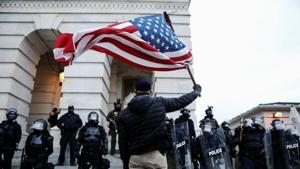A supporter of Donald Trump holds the American flag while confronting law enforcement officers at the US Capitol, in Washington on Wednesday.(Reuters Photo) A supporter of Donald Trump holds the American flag while confronting law enforcement officers at the US Capitol, in Washington on Wednesday.(Reuters Photo)