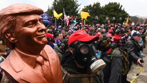 A supporter of US President Donald Trump wears a gas mask and holds a bust of him after he and hundreds of others stormed the Capitol building.(AFP) A supporter of US President Donald Trump wears a gas mask and holds a bust of him after he and hundreds of others stormed the Capitol building.(AFP)