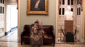 A supporter of President Donald Trump takes a seat away from the action on the second floor of the US Capitol near the entrance to the Senate after breaching security defenses, in Washington.(REUTERS) A supporter of President Donald Trump takes a seat away from the action on the second floor of the US Capitol near the entrance to the Senate after breaching security defenses, in Washington.(REUTERS)