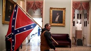 A supporter of President Donald Trump carries a Confederate battle flag on the second floor of the US Capitol near the entrance to the Senate after breaching security defenses, in Washington, US.(REUTERS) A supporter of President Donald Trump carries a Confederate battle flag on the second floor of the US Capitol near the entrance to the Senate after breaching security defenses, in Washington, US.(REUTERS)