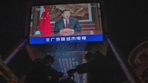 Security guards change shift under a screen showing Chinese President Xi Jinping delivering a speech for the evening news broadcast in Beijing on December 31.(AP file) Security guards change shift under a screen showing Chinese President Xi Jinping delivering a speech for the evening news broadcast in Beijing on December 31.(AP file)