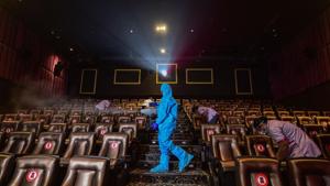 A worker wearing PPE kit sanitises a cinema hall in Chennai.(PTI)