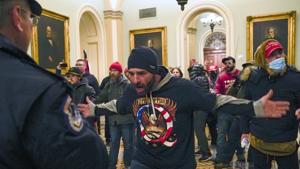 Trump supporters gesture to US Capitol Police in the hallway outside of the Senate chamber after breaching the halls of the Capitol in Washington.(AP) Trump supporters gesture to US Capitol Police in the hallway outside of the Senate chamber after breaching the halls of the Capitol in Washington.(AP)