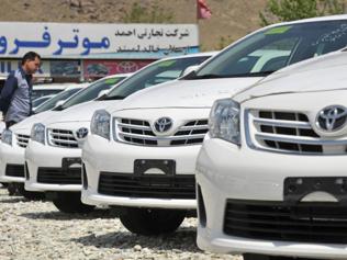 In-a-picture-taken-on-April-22-2013-a-potential-Afghan-customer-browses-through-parked-Toyota-Corolla-cars-at-an-auto-dealership-in-Kabul-Cheap-robust-and-reliable-consumer-culture-may-be-relatively-new-to-Afghanistan-but-when-it-comes-to-cars-there-is-a-clear-favourite-the-trusty-Toyota-Corolla-In-a-country-where-even-paved-roads-in-the-smartest-parts-of-the-capital-are-riddled-with-pot-holes-the-sturdy-Japanese-made-car-is-the-vehicle-of-choice-for-all-but-the-richest--Photo-AFP-Manjunath-Kira