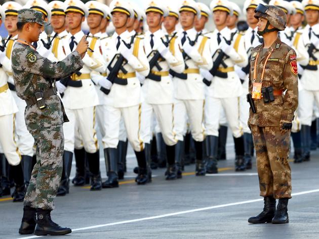 A soldier of the People's Liberation Army (PLA) of China has his picture taken as others march in formation past the Tiananmen Square before the military parade. The road through Doklam could allow the Chinese to further run roughshod over a key precept of India’s foreign policy.(Reuters) A soldier of the People's Liberation Army (PLA) of China has his picture taken as others march in formation past the Tiananmen Square before the military parade. The road through Doklam could allow the Chinese to further run roughshod over a key precept of India’s foreign policy.(Reuters)