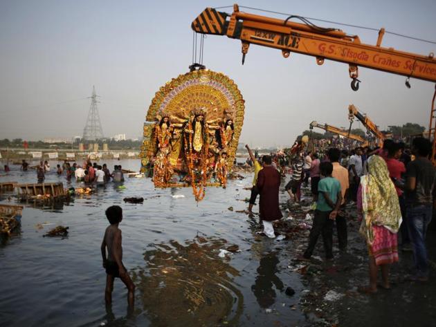 A giant Idol of Hindu goddess Durga suspends from a crane before it is immersed in the River Yamuna during Durga Puja festival in New Delhi.(AP File Photo)