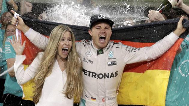 Mercedes driver Nico Rosberg of Germany celebrates with his wife Vivian Sibold holding a German flag in the team garage after winning the F1 2016 Championship in the Emirates Formula One Grand Prix at the Yas Marina racetrack in Abu Dhabi. (AP Photo)