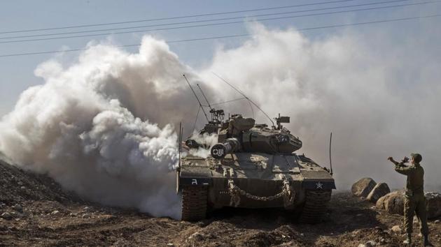 An Israeli soldier directs a Merkava tank near the border with Syria in the Israeli-annexed Golan Heights, on November 28, 2016. Israel's air force targeted gunman linked to the Islamic State group in Syria overnight, the army said, after they fired on an Israeli soldier in the occupied Golan Heights. (AFP) An Israeli soldier directs a Merkava tank near the border with Syria in the Israeli-annexed Golan Heights, on November 28, 2016. Israel's air force targeted gunman linked to the Islamic State group in Syria overnight, the army said, after they fired on an Israeli soldier in the occupied Golan Heights. (AFP)