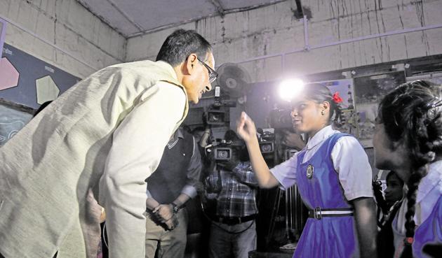 Chief minister Shivraj Singh Chouhan interacts with school students in Bhopal on Tuesday. The BJP marked the completion of Chouhan’s 11 years in office as deepotsav, the festival of lights, and lit earthen lamps at public venues.(Mujeeb Faruqui/HT photo)