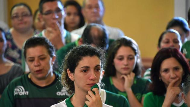 The names of each of the 71 victims of Monday night’s crash was read aloud while a military band played military taps while the Black Hawk helicopters that helped in the rescue operations that pulled six people alive from the wreckage flew overhead. (Nelson Almeida/AFP)