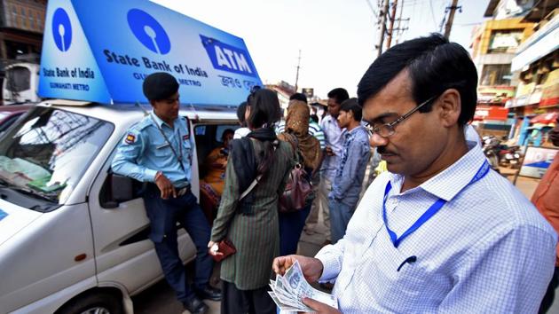 A man counts 100 Indian rupee banknotes after withdrawing them from a mobile ATM van in Guwahati on November 25. (Reuters) A man counts 100 Indian rupee banknotes after withdrawing them from a mobile ATM van in Guwahati on November 25. (Reuters)