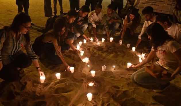 Youngsters form a ribbon (symbol of AIDS awareness) with candles on occasion of World AIDS Day, at Juhu on Thursday. (HT Photo) Youngsters form a ribbon (symbol of AIDS awareness) with candles on occasion of World AIDS Day, at Juhu on Thursday. (HT Photo)