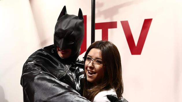 A woman poses for pictures with a man wearing a Batman costume during Tokyo Comic Con. (AFP)