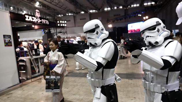 A Japanese woman in traditional Kimino walks past people wearing Star Wars characters' costumes during Tokyo Comic Con. (AFP)