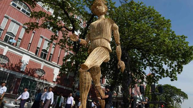 Residents look at an eight-metre-tall wicker puppet walk past colonial buildings in central Yangon. The three-day-long festival, which is being held to celebrate 55 years of French-Myanmar relations, brings together local and international artists (street art, music, circus and dance) to bring cheer and festivities to Yangon's public areas. (AFP)