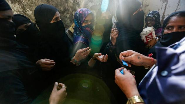A bank employee gives entry tokens to people as they wait for their turn to exchange or deposit their old high denomination banknotes outside a bank in a slum in Mumbai, India on November 30, 2016. (Danish Siddiqui /REUTERS) A bank employee gives entry tokens to people as they wait for their turn to exchange or deposit their old high denomination banknotes outside a bank in a slum in Mumbai, India on November 30, 2016. (Danish Siddiqui /REUTERS)