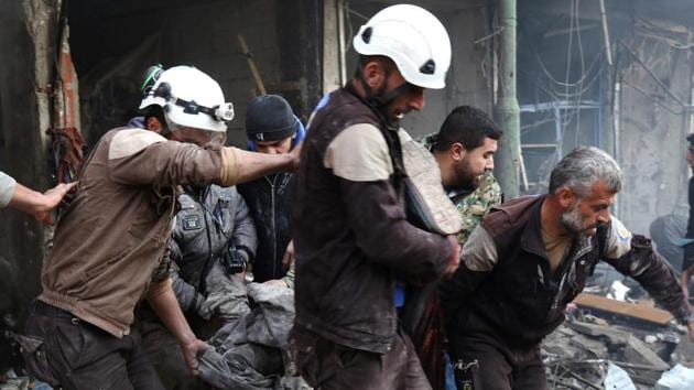 Syrian men and Civil Defence volunteers evacuate a victim from a building following an air strike on the village of Maaret al-Numan, in Idlib.(AFP Photo)