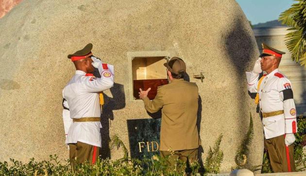 Cuba's President Raul Castro places the ashes of his older brother Fidel Castro into a niche in his tomb, a simple, grey, round stone about 15 feet high at the Santa Ifigenia cemetery in Santiago, Cuba on December 4. (AP) Cuba's President Raul Castro places the ashes of his older brother Fidel Castro into a niche in his tomb, a simple, grey, round stone about 15 feet high at the Santa Ifigenia cemetery in Santiago, Cuba on December 4. (AP)