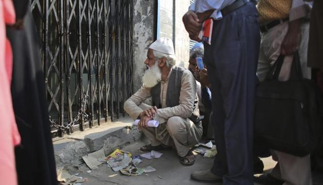 An elderly man squats on the pavement as he waits in a queue to deposit and exchange discontinued currency notes outside a bank in New Delhi.(AP Photo) An elderly man squats on the pavement as he waits in a queue to deposit and exchange discontinued currency notes outside a bank in New Delhi.(AP Photo)