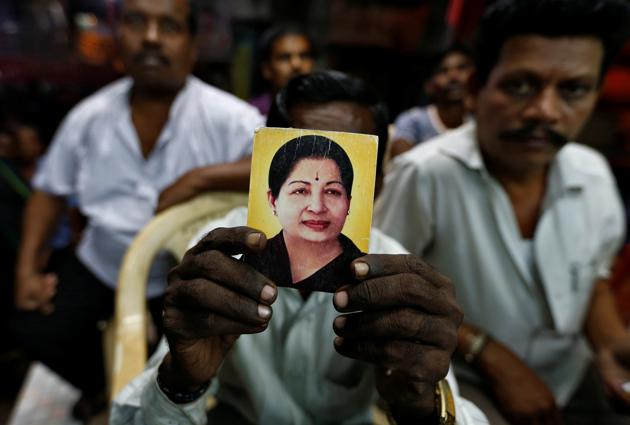A supporter of Tamil Nadu chief minister Jayalalithaa holds her photo at the AIADMK party office in Mumbai. (REUTERS)