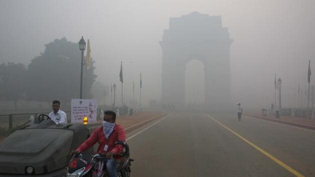 A man covers his face with a scarf as he rides in front of India Gate, enveloped by smoke and smog, in New Delhi. (AP Photo) A man covers his face with a scarf as he rides in front of India Gate, enveloped by smoke and smog, in New Delhi. (AP Photo)