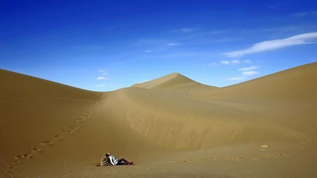 An Iranian woman relaxes on the sands. Mesr desert and its oasis are known as Dashte-Kavir in Persian. (AP)