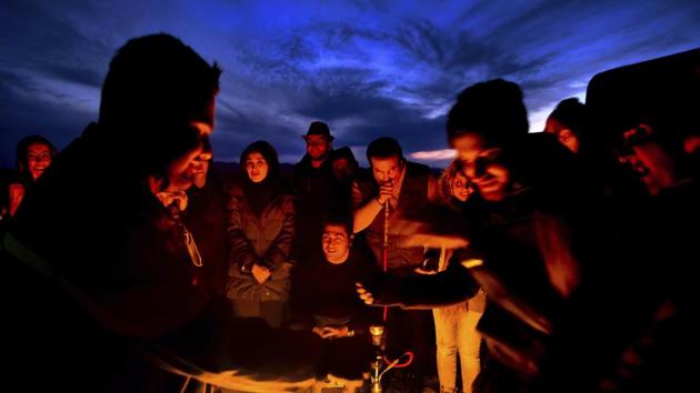 Iranian youths warm themselves by a fire in the Khour salt lake. A popular spot for tourists, sunset gazing is encouraged here. (AP)