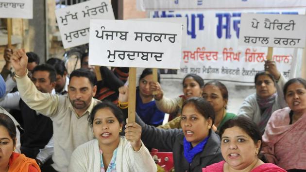 Members of Medical Laboratory Technician Association protestingt at Civil Surgeon office in Ludhiana on Tuesday.(Gurminder Singh/HT Photo)
