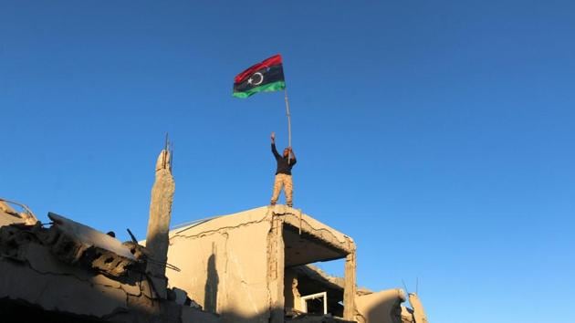 A fighter of Libyan forces allied with the U.N.-backed government waving a Libyan flag flashes victory sign as he stands atop the ruins of a house after forces finished clearing Ghiza Bahriya, the final district of the former Islamic State stronghold of Sirte, Libya. (REUTERS) A fighter of Libyan forces allied with the U.N.-backed government waving a Libyan flag flashes victory sign as he stands atop the ruins of a house after forces finished clearing Ghiza Bahriya, the final district of the former Islamic State stronghold of Sirte, Libya. (REUTERS)