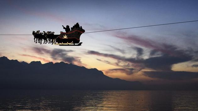 Santa Claus waves to the crowd from his flying sleigh drawn by reindeer over the Geneva Lake in front of the Swiss and French alps, on the first day of the 22nd edition of the Christmas Market in Montreux, Switzerland on December 6, 2016. (AP) Santa Claus waves to the crowd from his flying sleigh drawn by reindeer over the Geneva Lake in front of the Swiss and French alps, on the first day of the 22nd edition of the Christmas Market in Montreux, Switzerland on December 6, 2016. (AP)