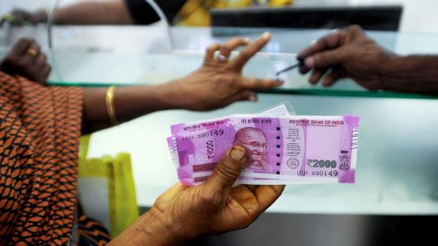 A woman displays her 2000 rupee notes as she has her finger inked with indelible ink after exchanging withdrawn 500 and 1000 rupee banknotes at a bank.(AFP File Photo)