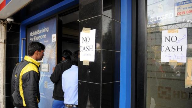 People stand outside an ATM displaying ‘No Cash’ notice, in Gurgaon.(Parveen KumarHT Photo)