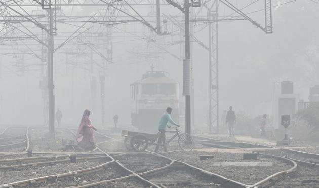 People cross railway track amid dense fog at New Delhi Railway station on Thursday. (Raj K Raj/ HT Photo) People cross railway track amid dense fog at New Delhi Railway station on Thursday. (Raj K Raj/ HT Photo)