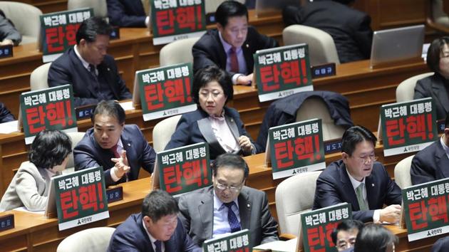 Lawmakers of opposition parties wait for the plenary session as they put placards reading "President Park Geun-hye, Impeachment" at the National Assembly in Seoul on Thursday. (AP) Lawmakers of opposition parties wait for the plenary session as they put placards reading "President Park Geun-hye, Impeachment" at the National Assembly in Seoul on Thursday. (AP)