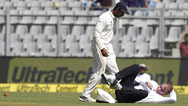 Umpire Paul Reiffel falls after being hit by a ball during day 1 of the fourth Test between India and England held at Wankhede Stadium, Mumbai on Thursday.(BCCI)