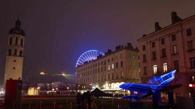 The ferris wheel of Place Bellecour (rear), the bell tower (L) and an illuminated plane sculpture inspired by Vol de Nuit (Night Flight, Antoine de Saint-Exupery's 1931 novel) are pictured in downtown Lyon. (AFP)