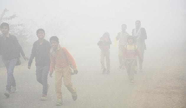 Children go to school amid dense fog in Dasna village near NH 24, Ghaziabad, on Friday.(Sakib Ali/HT Photo)