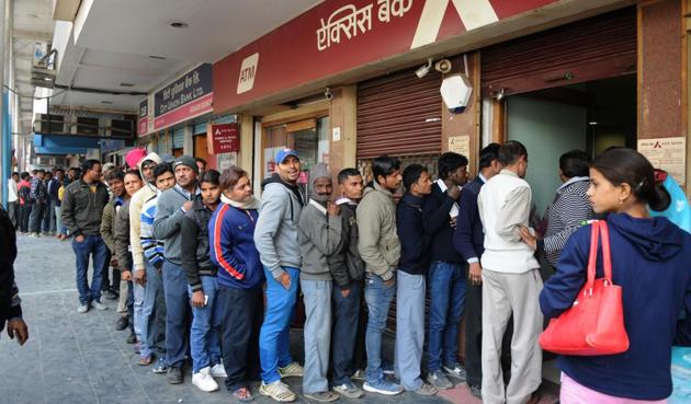 People line up outside the Axis Bank branch in Sector 14 on Thursday to withdraw cash.(Parveen Kumar/HT Photo)