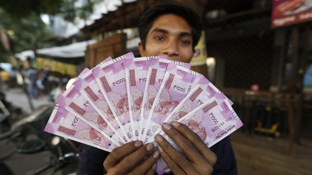 A man displays new currency notes in Ahmadabad/(AP File Photo)