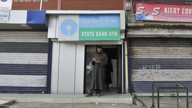 A man emerges from an ATM in Sopore in north Kashmir after withdrawing money. After demonetisation, queues outside banks and ATMs in Kashmir have been without rush unlike that in other parts of the country.(Waseem Andrabi/Hindustan Times)