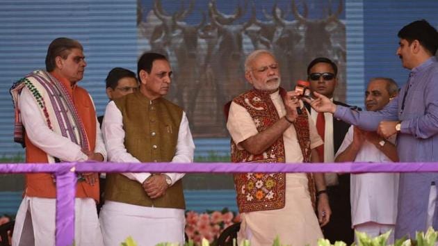 Prime Minister Narendra Modi holding a bottle of Banas Honey to mark its launch in Banaskantha district.(Twitter/@PIB_India)