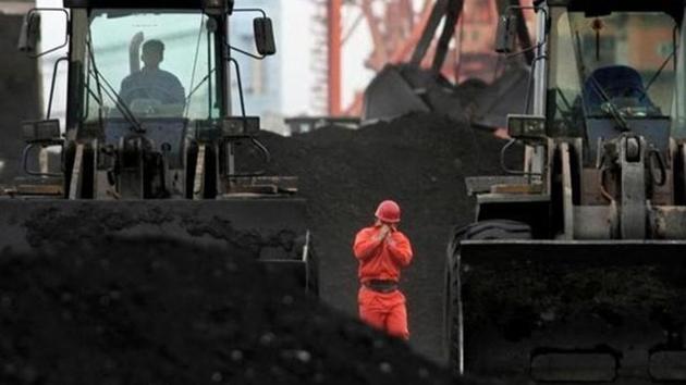 An employee walks between front-end loaders which are used to move coal imported from North Korea at Dandong port in the Chinese border city of Dandong, Liaoning province.(Reuters File Photo)