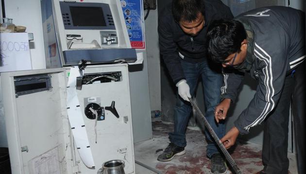 Investigators at the Central Bank ATM where the guard was murdered.(Ajay Dubey/HT) Investigators at the Central Bank ATM where the guard was murdered.(Ajay Dubey/HT)